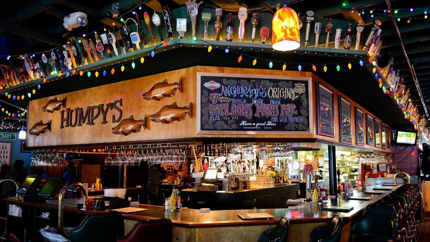 Interior of Humpy's Great Alaskan Alehouse in downtown Anchorage, Alaska — warm tungsten bar lighting, wood paneling, beer tap handles, and the signature alehouse atmosphere that has defined Anchorage nightlife since 1994